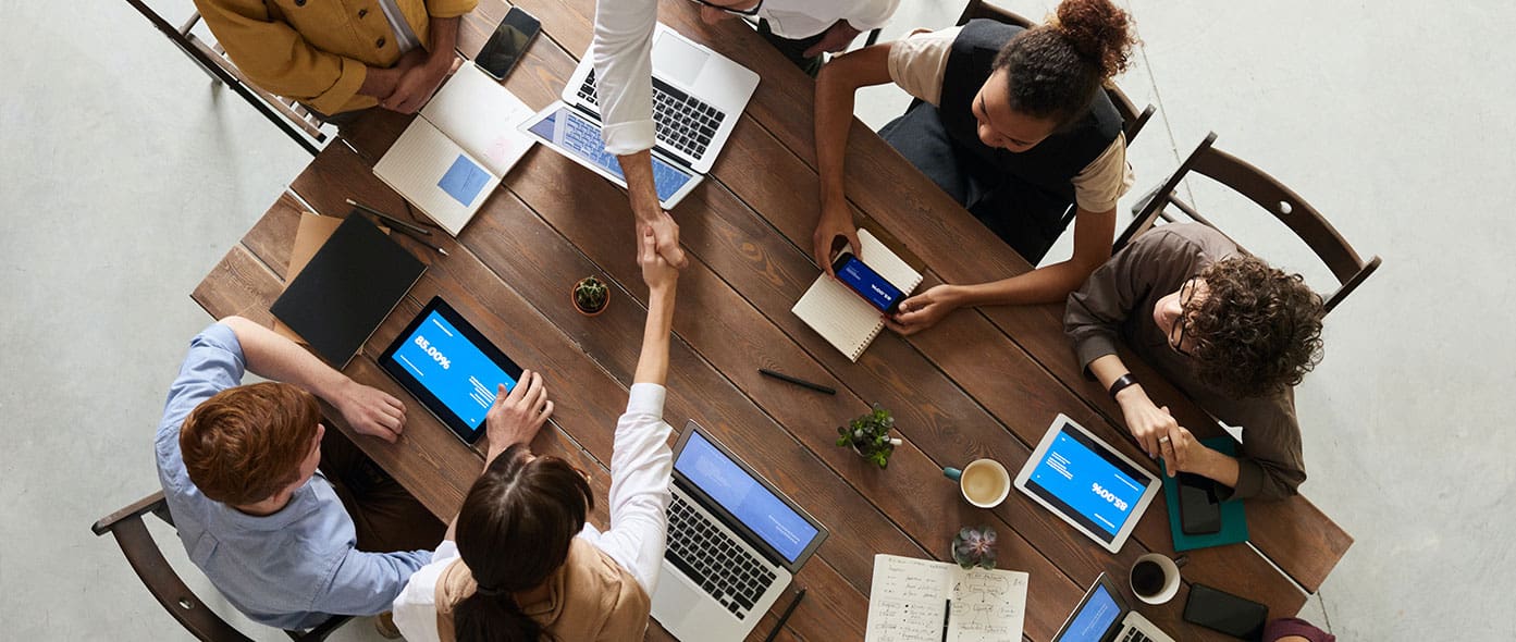 Team Shaking Hands Accross Table